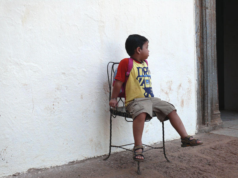 Manu sitting in a chair outside Bom Jesus Church, copyright Picturejockey : Navin Harish 2005-2009