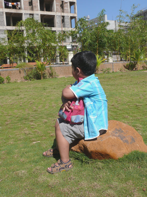 Manu sitting on a rock holding his bag outside Ginger Hotel, Goa, copyright Picturejockey : Navin Harish 2005-2009