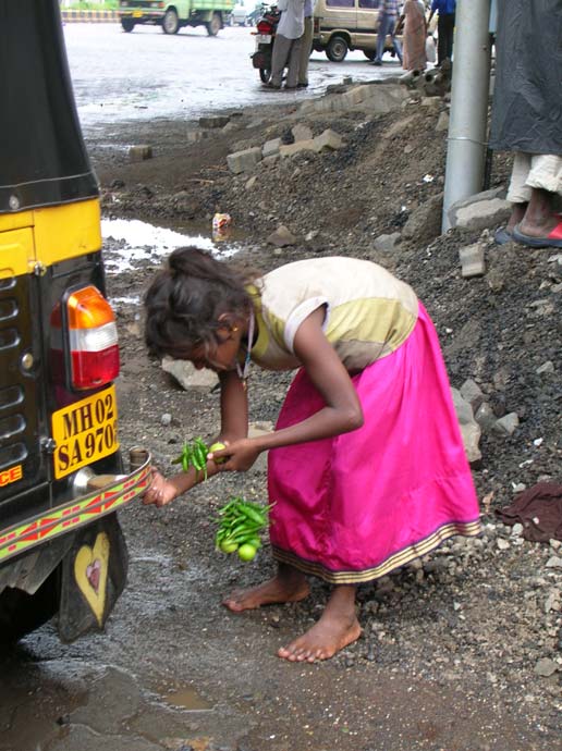 Girl tying chilli lemons to rickshaw