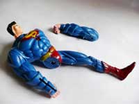 ...an arm... - An image of a broken superman toy with its arm next to it 