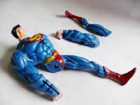 ...and a leg to have a body like Arnold Schwarzenegger - An image of a broken superman toy with its broken arm leg next to it