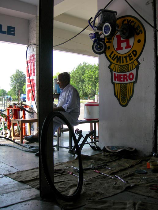 Hero - An image of an old man sitting outside a bicycle shop waiting for his bicycle's tyres to be changed  | copyright Picturejockey : Navin Harish 2005-2007