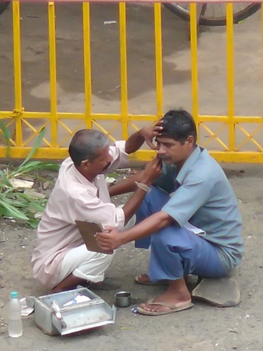 Mobile barber - An image of a barber shaving a man outside Fantasy Land in Mumbai, India | copyright Picturejockey : Navin Harish 2005-2007