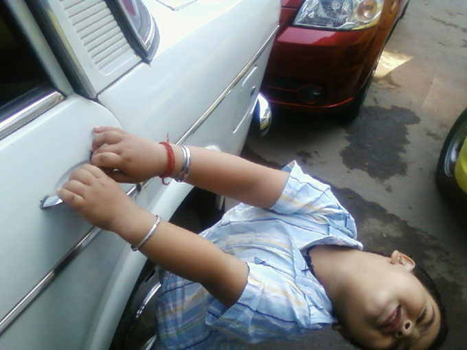 You are smarter than you think - An image of Manu trying to open the door of a Fiat mistaking it to be taxi | copyright Picturejockey : Navin Harish 2005-2008