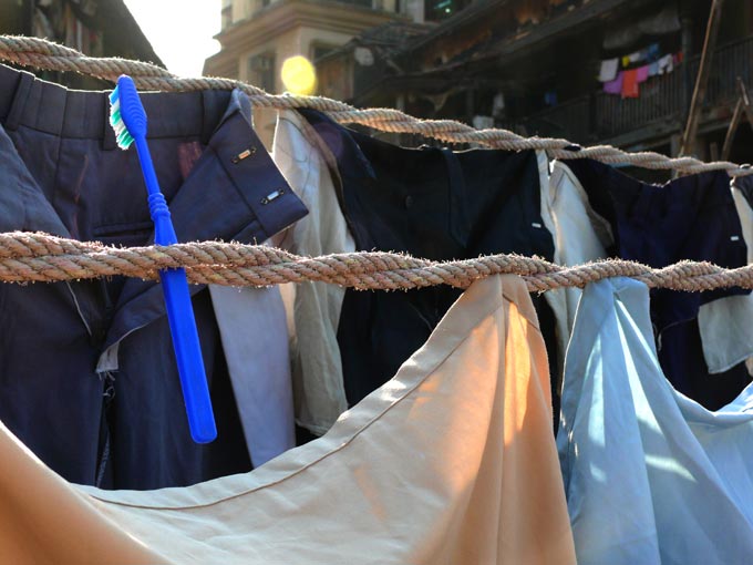 Don't forget to floss  - An image of a clothes' line in a public laundry in Walkeshwar with a tooth brush stuck in it  | copyright Picturejockey : Navin Harish 2005-2008