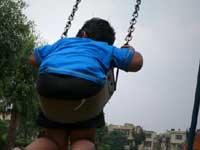 Here I come... Here I go - An image of Manu on a swing the park near my home in Delhi