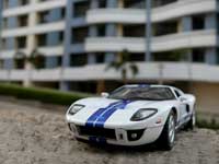 Buy a house, get a car free : A White Ford GT parked outside a building