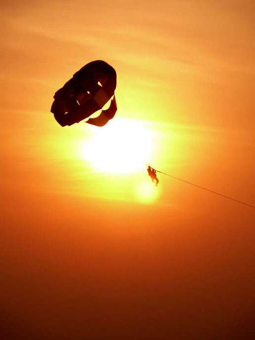 Two men parasailing with the sun in the background , copyright Picturejockey : Navin Harish 2005-2009