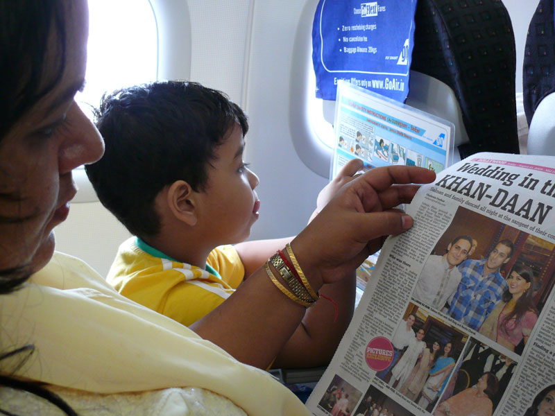 Mira reading Mid-day and Many reading the safety instructions aboard a Go Air plane from Mumbai to Delhi, copyright Picturejockey : Navin Harish 2005-2009